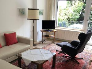 uma sala de estar com um sofá e cadeiras e uma televisão em Ferienwohnung Sommerfeld em Bad Sassendorf