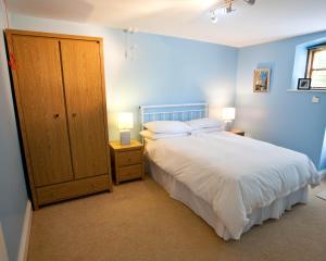 リマバディにあるBallyhenry House and Apartmentsの白いベッドと青い壁が備わるベッドルーム1室が備わります。