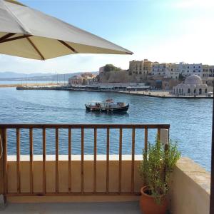 a boat in a body of water with an umbrella at Captain Vasilis Hotel in Chania Town