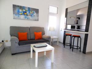 エル・メダノにあるApartamentos Medano - Playa Grandeのリビングルーム(ソファ、テーブル付)