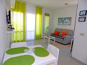 エル・メダノにあるApartamentos Medano - Playa Grandeのリビングルーム(テーブル、ソファ付)