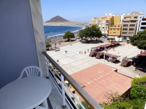 a balcony with a table and a view of a beach at Apartamentos Medano - Playa Grande in El Médano