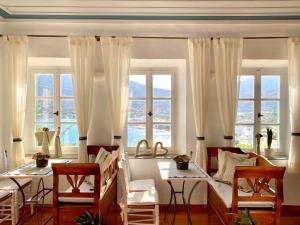 sala de estar con 1 cama y 2 ventanas en Niriedes Hotel, en Platis Yialos Sifnos
