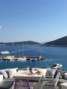 een patio met uitzicht op een haven met boten bij Niriedes Hotel in Platis Yialos Sifnos