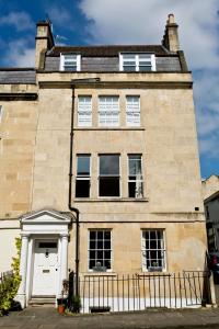 a large brick house with a white door at Central Courtyard Apartment in Bath