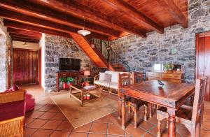 a living room with a table and a stone wall at Seixal Sunny Villa A & B by Amazing Madeira in Seixal
