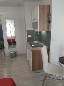 eine kleine Küche mit einer Spüle und einem Stuhl in der Unterkunft Apartman Viola Mareda in Novigrad Istria