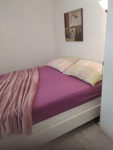ein Bett mit einer lila Decke darüber in der Unterkunft Apartman Viola Mareda in Novigrad Istria