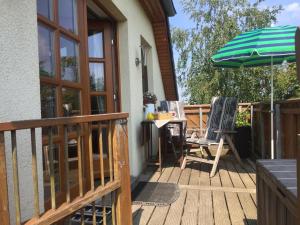 a patio with a table and an umbrella at Ferienwohnung Stockrose in Middelhagen