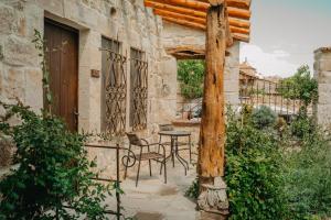 a patio with a table and chairs on a building at Dere Suites Cappadocia in Ürgüp