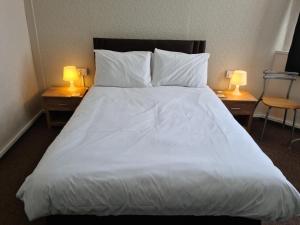 a bedroom with a large white bed with two lamps at Royal Albion Walton in Walton-on-the-Naze