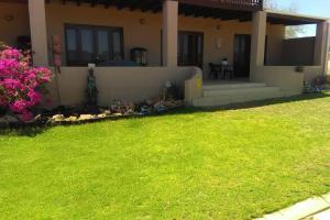 a house with a green lawn in front of it at Oppidam Self Catering in Clanwilliam