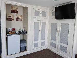 a room with white cabinets and a flat screen tv at Royal Albion Walton in Walton-on-the-Naze