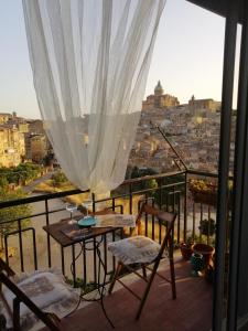 einen Balkon mit einem Tisch und Stühlen sowie Stadtblick in der Unterkunft Appartamento d'Artista in Piazza Armerina
