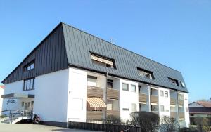 a large white building with a black roof at Appartementhäuser Herbert und Walter in Bad Füssing