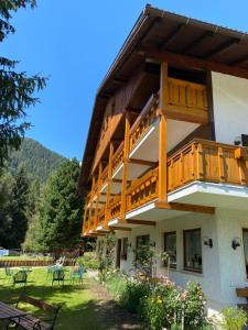 a building with a balcony with tables and chairs at Hotel Friedemann in Rasùn di Sotto