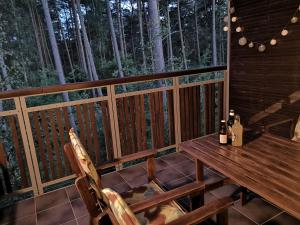 a wooden table and chairs on a deck with trees at Sea&Forest Pogorzelica Apartament Srebrny in Pogorzelica