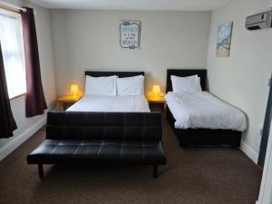 a living room with two beds and a leather couch at Royal Albion Walton in Walton-on-the-Naze +10 photos