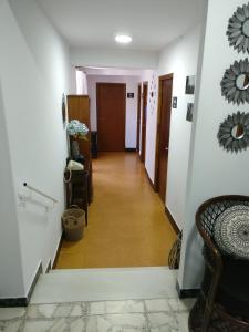 a hallway with white walls and a long hallway at Albergue Vintecatro in Caldas de Reis