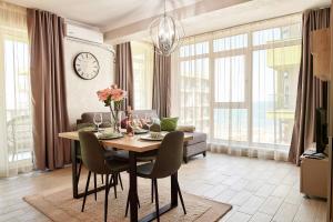 sala de estar con mesa con sillas y reloj en Berlin luxury apartment Spa n Pool Beach resort, en Mamaia Nord – Năvodari