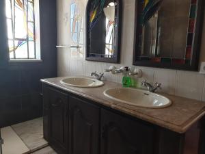 a bathroom with two sinks and stained glass windows at OceanOasis Residences Suites in Olhão