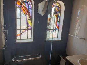 two stained glass windows in a bathroom with a shower at OceanOasis Residences Suites in Olhão