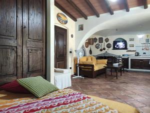 a bedroom with a bed and a living room at Casa Bados in Dorgali