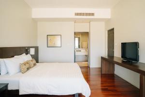 a bedroom with a bed and a flat screen tv at Inpawa Hotel in Ban Phai