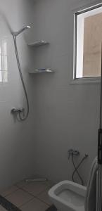 La salle de bains blanche est pourvue d'une douche et de toilettes. dans l'établissement Residence Anis mnakaa, à Sīdī ‘Ulwān