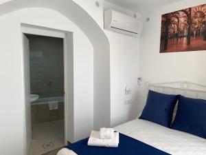 1 dormitorio con 1 cama con almohadas azules y baño en Belmonte Rooms, en Córdoba