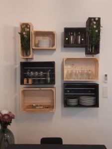 a wall with wooden drawers with plates and glasses at Chic and Cosy apartment close to the port and Garibaldi in Nice