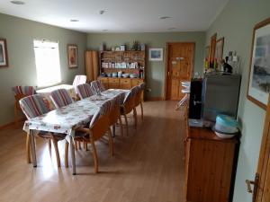 a dining room with a table and chairs and a television at Lough Gara Lodge Self Catering in Gorteen