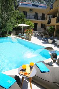 a swimming pool with a table and chairs next to a building at Hotel Alkima in Kotor