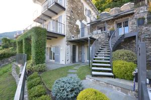 a house with a staircase in a yard at Casa di campagna Tony con piscina e vista lago in Gravedona