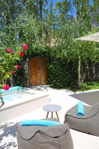 une terrasse avec 2 chaises, une table et des roses dans l'établissement Hotel Alkima, à Kotor