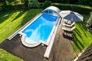 einen Blick über einen Pool mit Sonnenschirm in der Unterkunft Holiday House in Nature with Pool, Pr Matažič in Kamnik