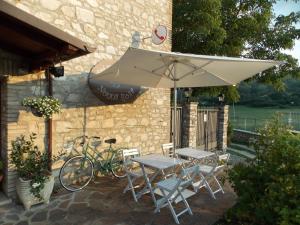 a table and chairs with an umbrella and a bicycle at B&B Nonna Rosa in Norcia +24 photos