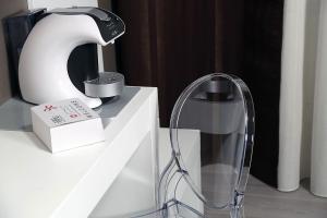 a lamp on a white table with a glass holder at Piccolo di Piazza di Spagna Suites in Rome