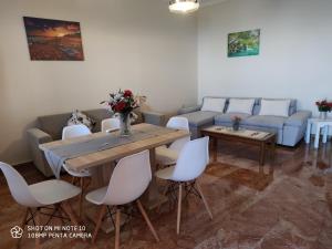 een woonkamer met een tafel en een bank bij San Vlassis Area Apartment in Lákones