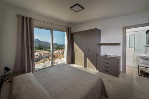 Un dormitorio con una cama y un baño con lavabo. en Giardino degli Allori - Villa Flores, en Castellammare del Golfo 17 fotos más