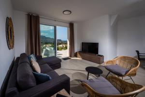 Una sala de estar con un sofá y sillas y un televisor. en Giardino degli Allori - Villa Flores, en Castellammare del Golfo