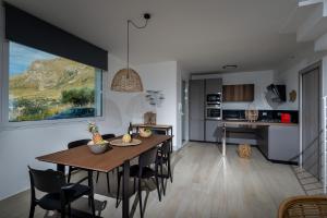 Una cocina y un comedor con mesa y sillas. en Giardino degli Allori - Villa Flores, en Castellammare del Golfo