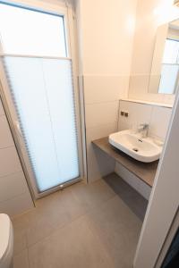 een badkamer met een wastafel en een raam bij Ostseehaus am Naturstrand - Arkonablick in Varnkevitz