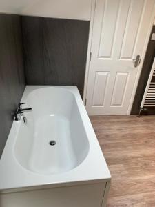 a bathroom with a white sink and a white door at Fox and Hounds Cottage, Starbotton in Starbotton