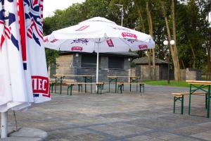 un groupe de tables et de parasols dans un parc dans l'établissement Hotel Promenada Biznes & Wypoczynek, à Radom