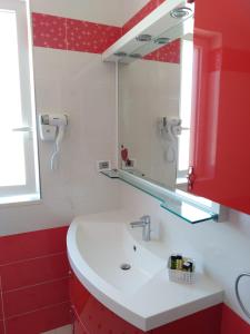 een badkamer met een wastafel en een spiegel bij PiGreco in Albenga