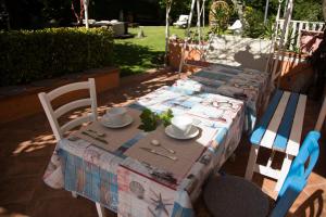 stół z 2 krzesłami i stół z tkaniną w obiekcie Alle Giare w Genui