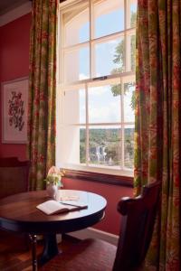 a table in a room with a window at Hotel das Cataratas, A Belmond Hotel, Iguassu Falls in Foz do Iguaçu