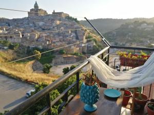 a hammock on a balcony overlooking a city at Appartamento d'Artista in Piazza Armerina
