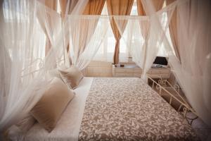 1 dormitorio con 1 cama con cortinas y ventana en I Trulli del Tupparello, en Fasano